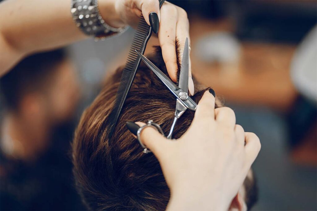 Homme en train de se faire couper les cheveux chez le coiffeur