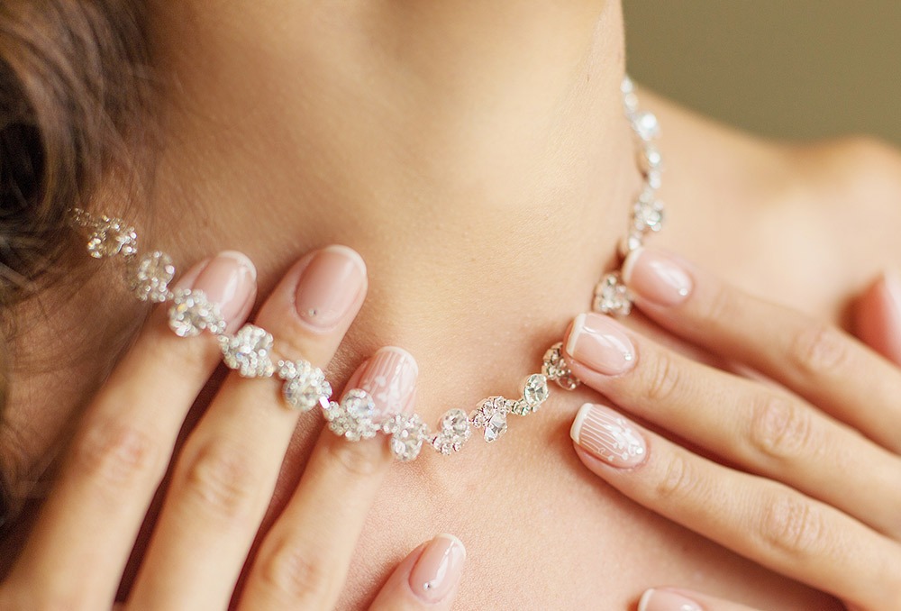Jolies mains tenant un collier brillant avec des strass