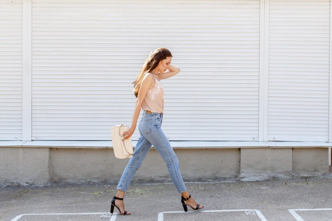 Jeune femme marchant dans la rue avec un jean slim
