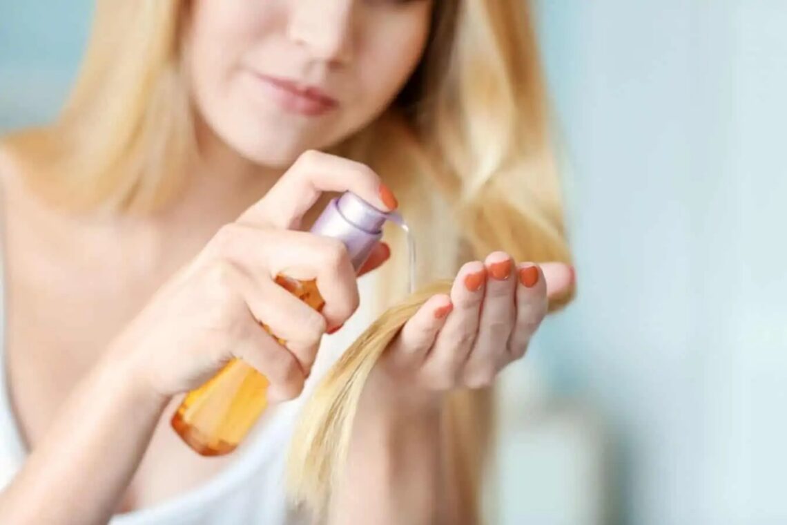 Jeune femme blonde met de l'huile sur ses cheveux